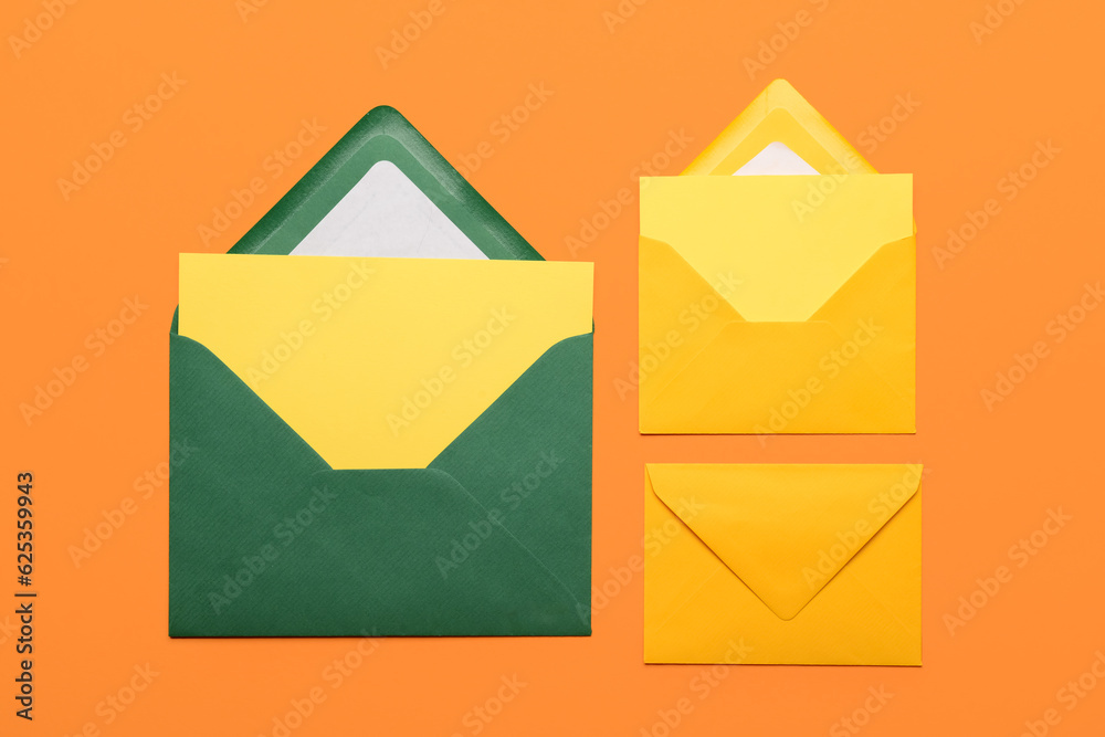 Set of different envelopes with blank cards on color background