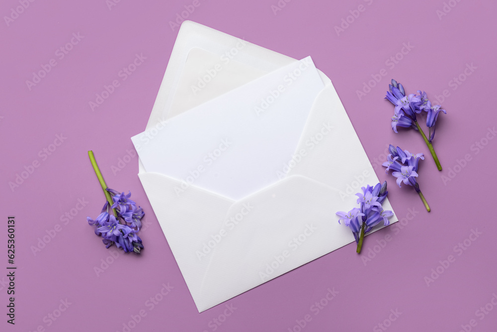 Paper envelope with blank card and flowers on color background