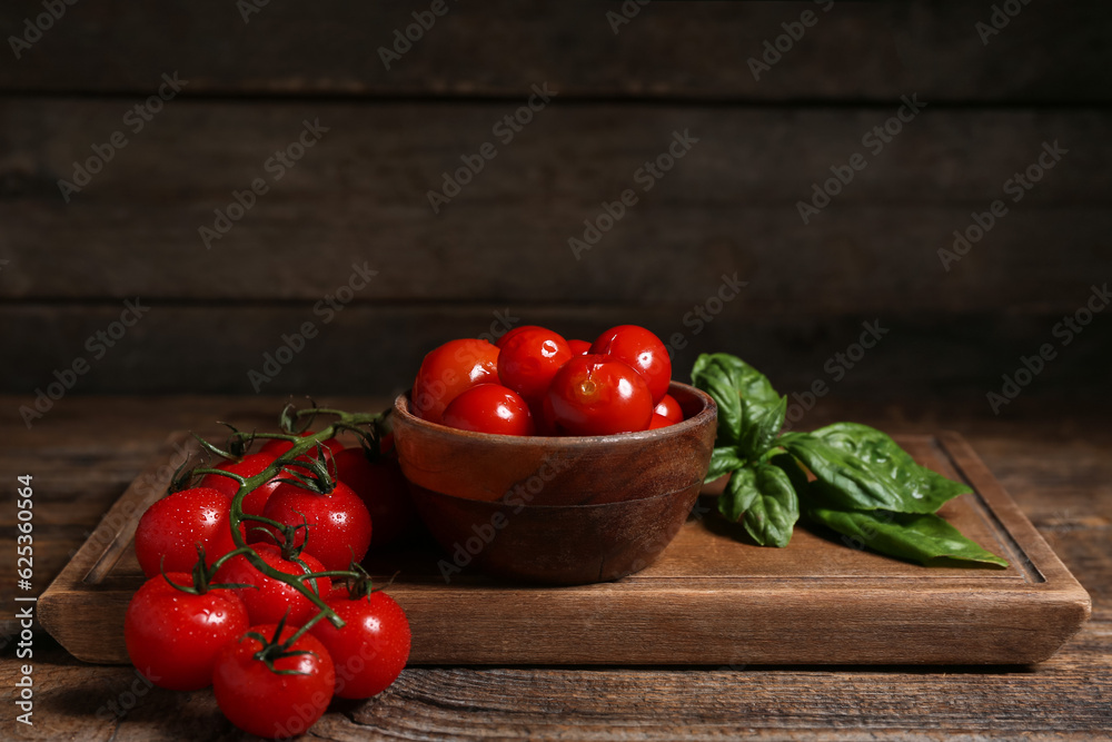 Bowl with canned tomatoes and basil on wooden background