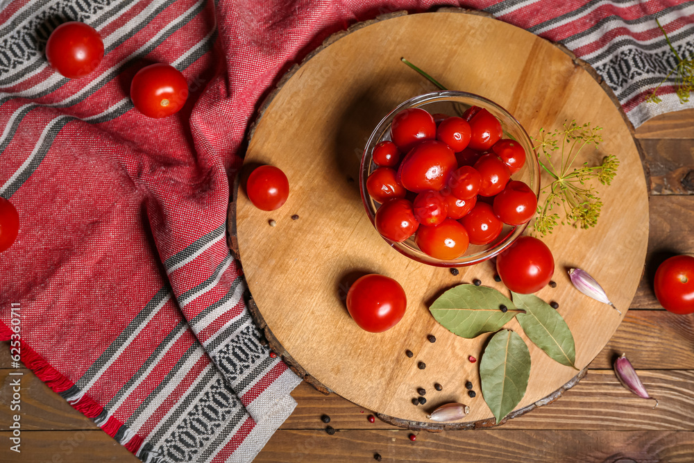 Glass bowl with canned tomatoes and peppercorn on wooden background