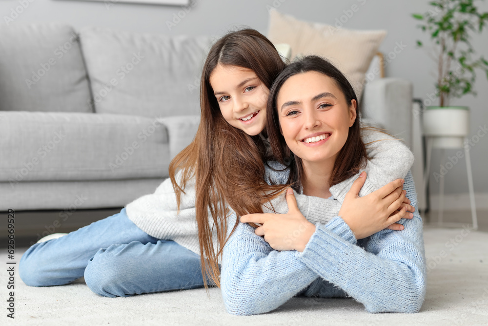 Little girl and her mother in knitted sweaters resting at home