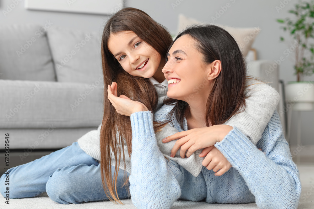 Little girl and her mother in knitted sweaters resting at home