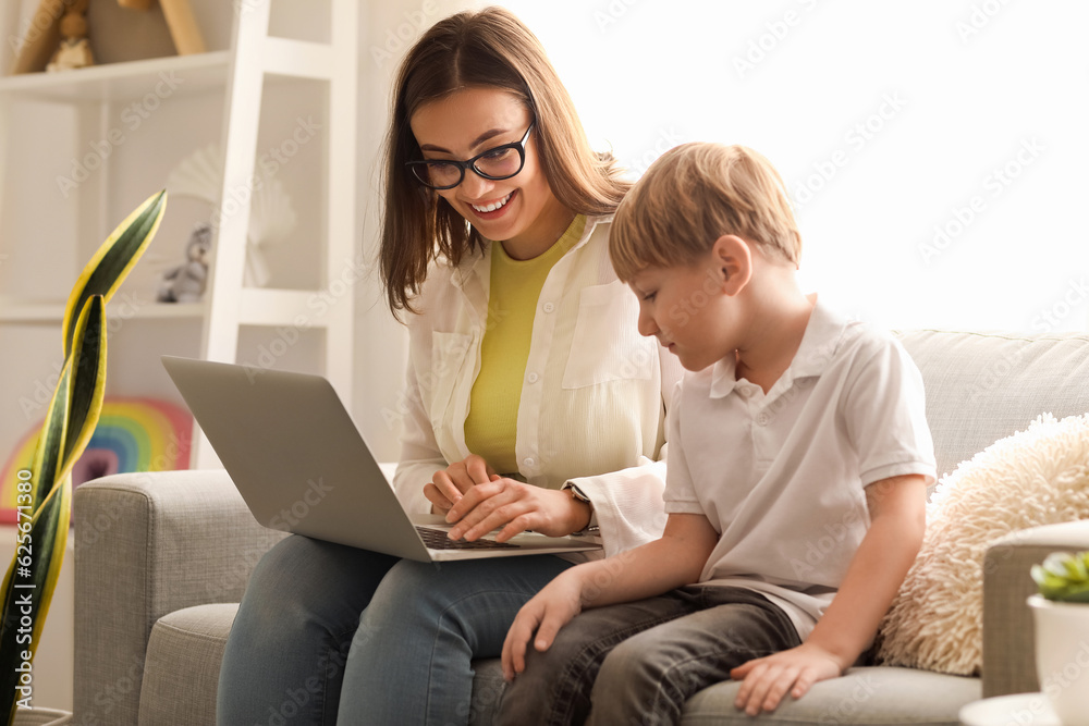 Nanny with little boy watching cartoons at home