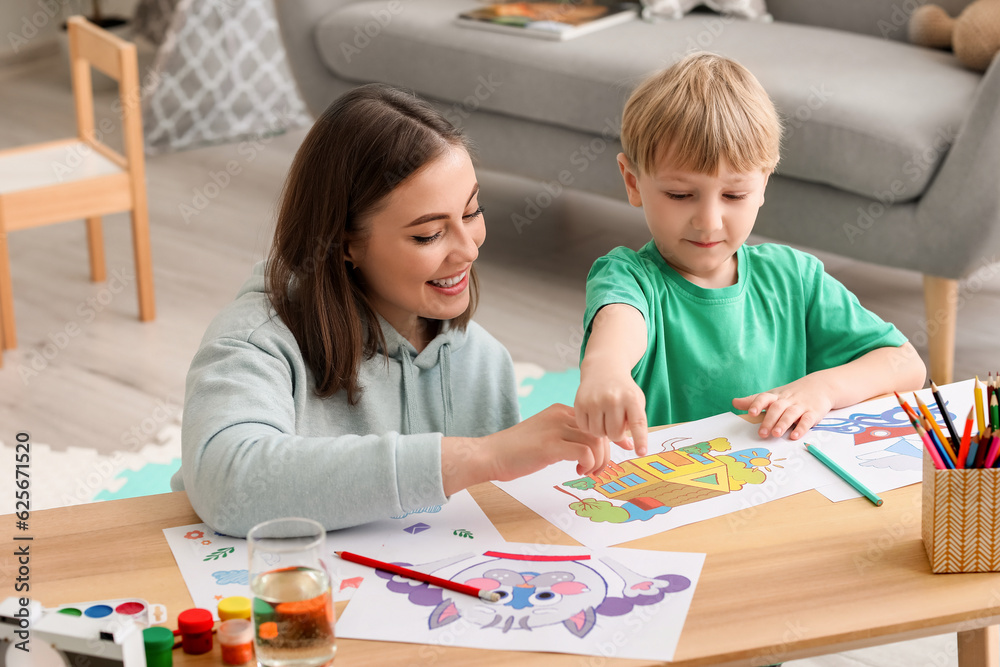 Nanny with little boy drawing at home