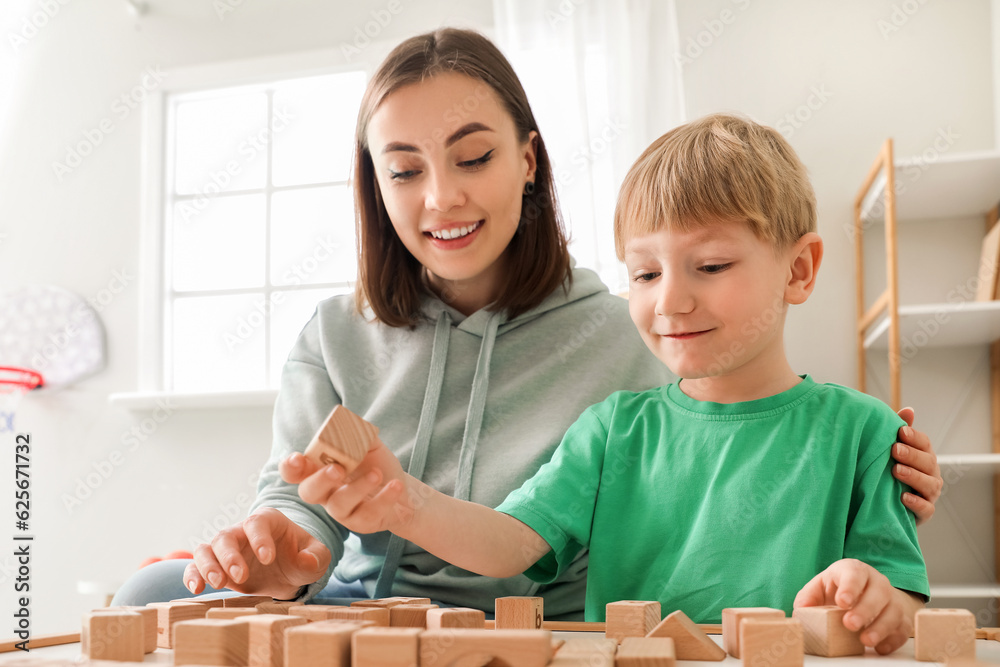 Little boy and nanny playing with cubes at home