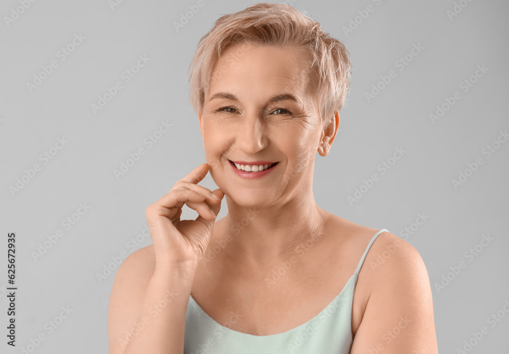 Mature woman with marked face for filler injection on light background