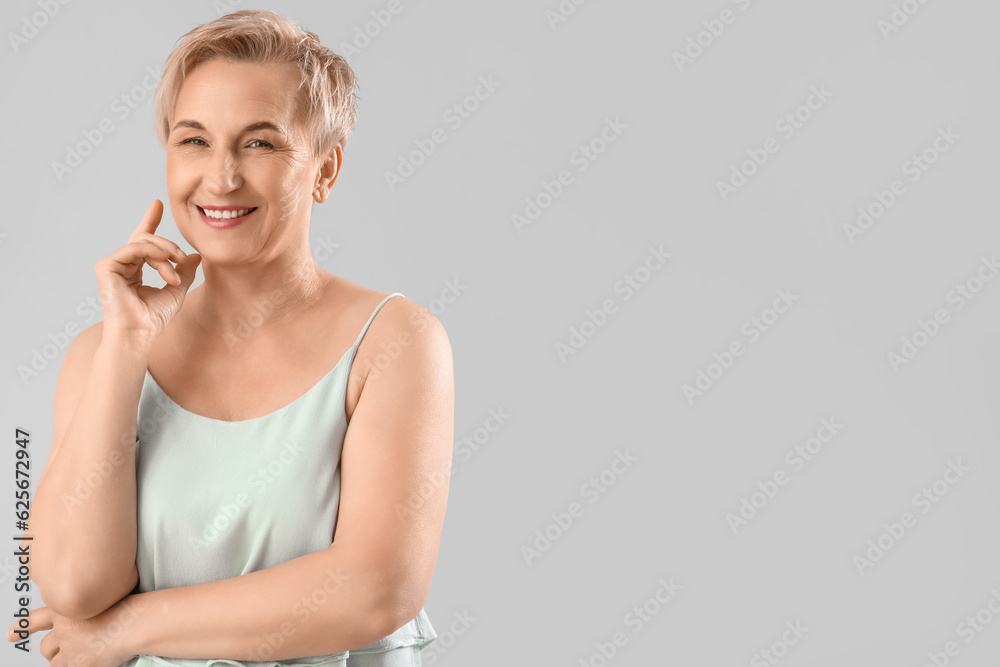 Mature woman with marked face for filler injection on light background