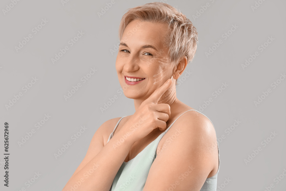 Mature woman with marked face for filler injection on light background