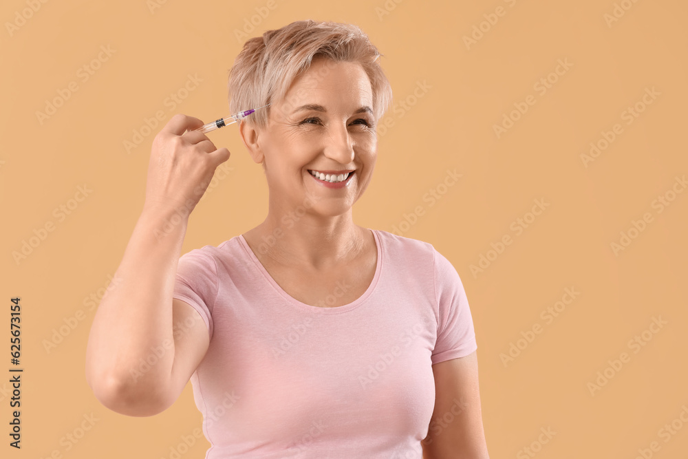 Mature woman with filler injection on beige background