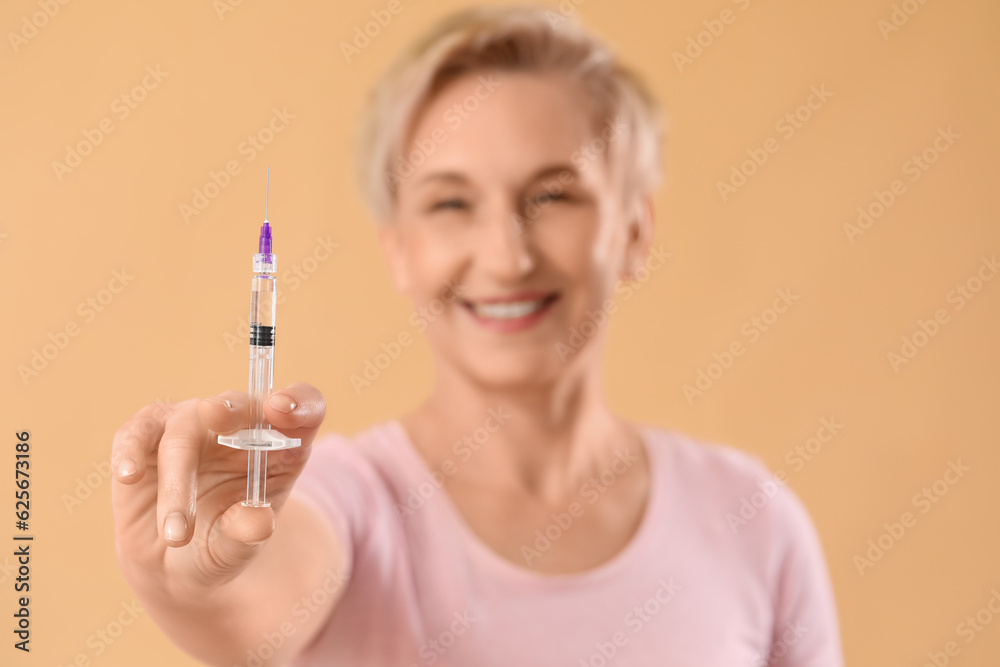 Mature woman with filler injection on beige background, closeup