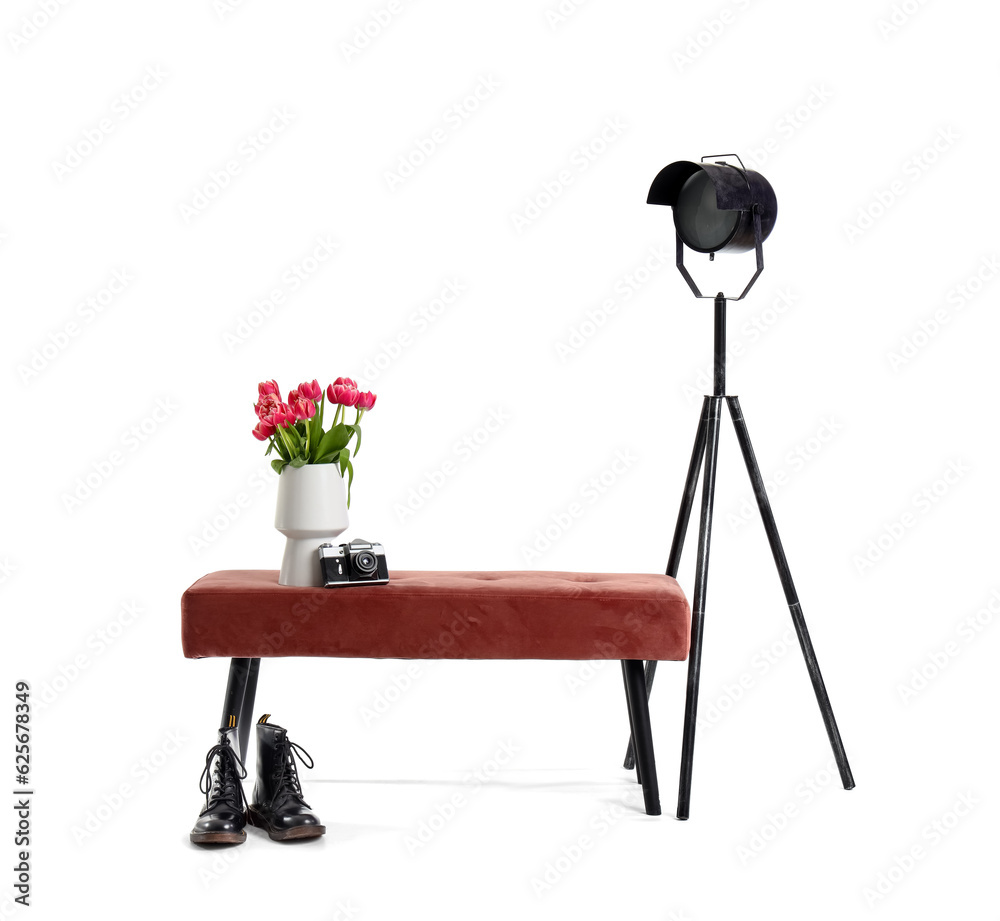 Vase with tulips, photo camera, pink bench, lamp and shoes on white background