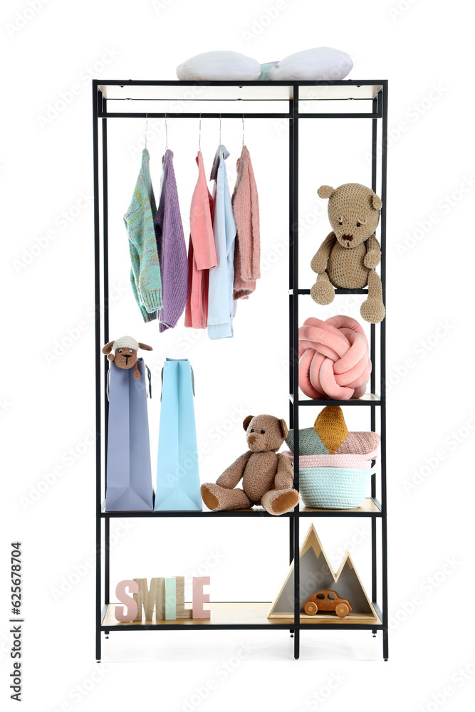 Shelving unit with childrens clothes and toys on white background