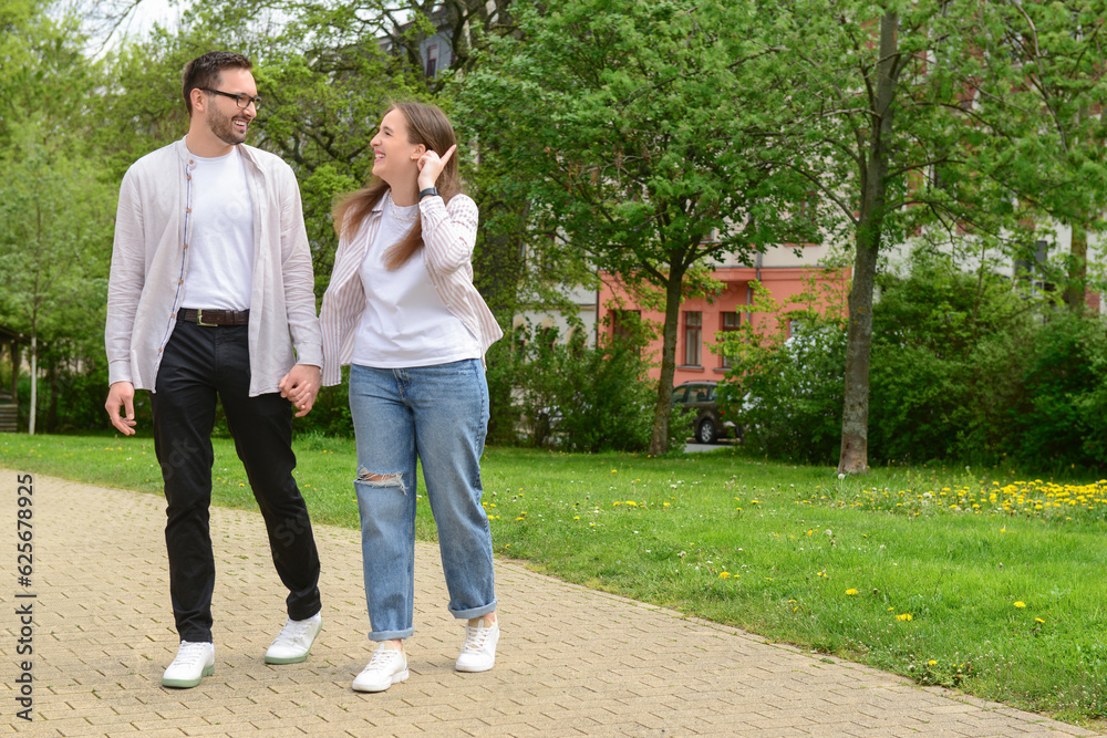 Beautiful happy couple walking in park on spring day