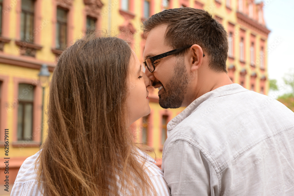 Beautiful happy couple kissing in city on spring day