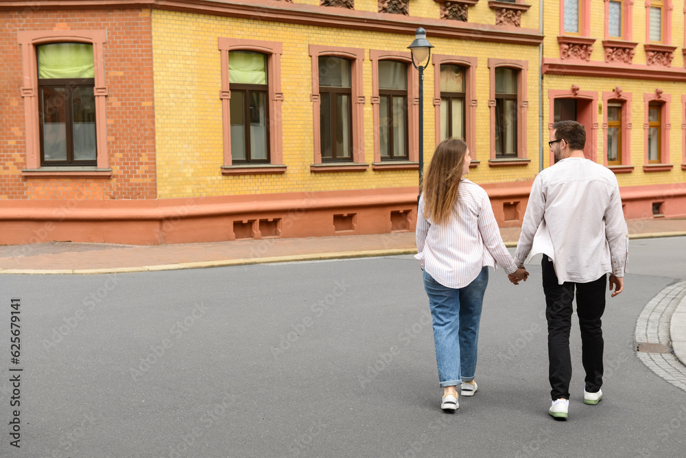 Beautiful happy couple walking in city on spring day