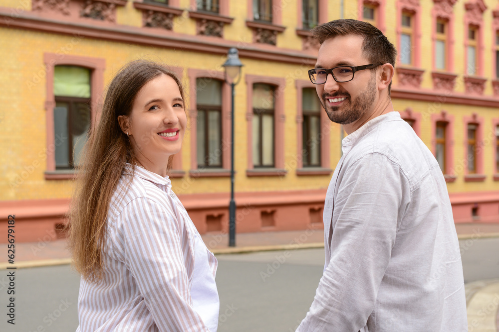 Beautiful happy couple walking in city on spring day