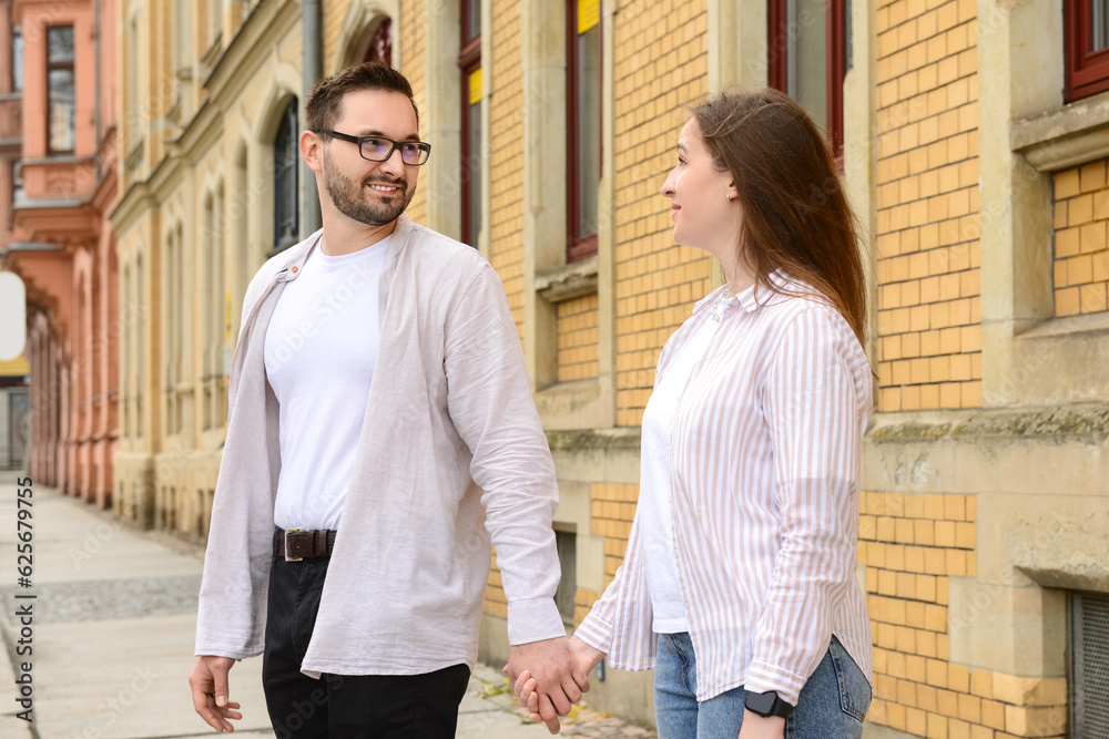 Beautiful loving happy couple walking in city on spring day