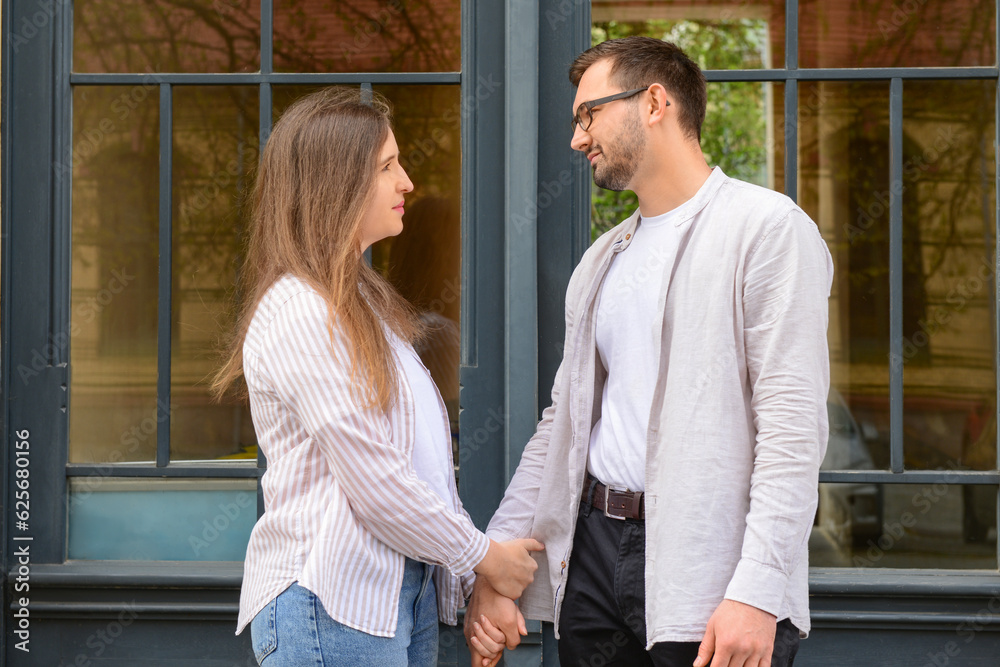 Beautiful loving couple walking in city on spring day