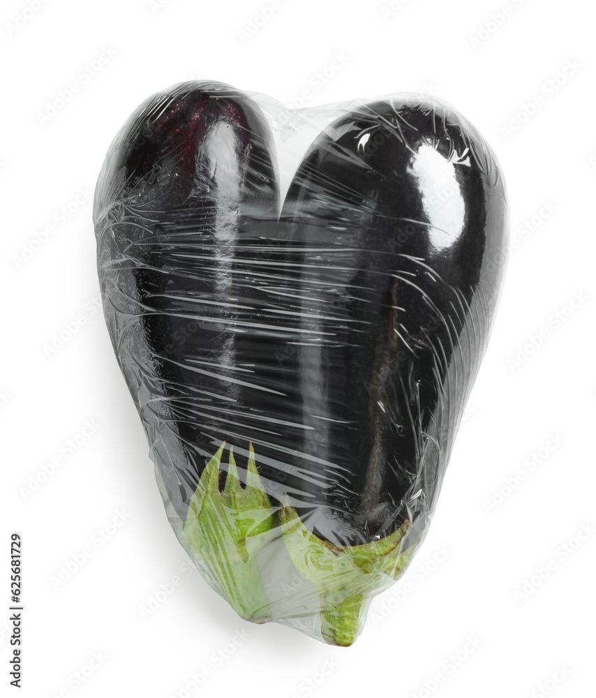 Fresh eggplant in plastic food wrap on white background