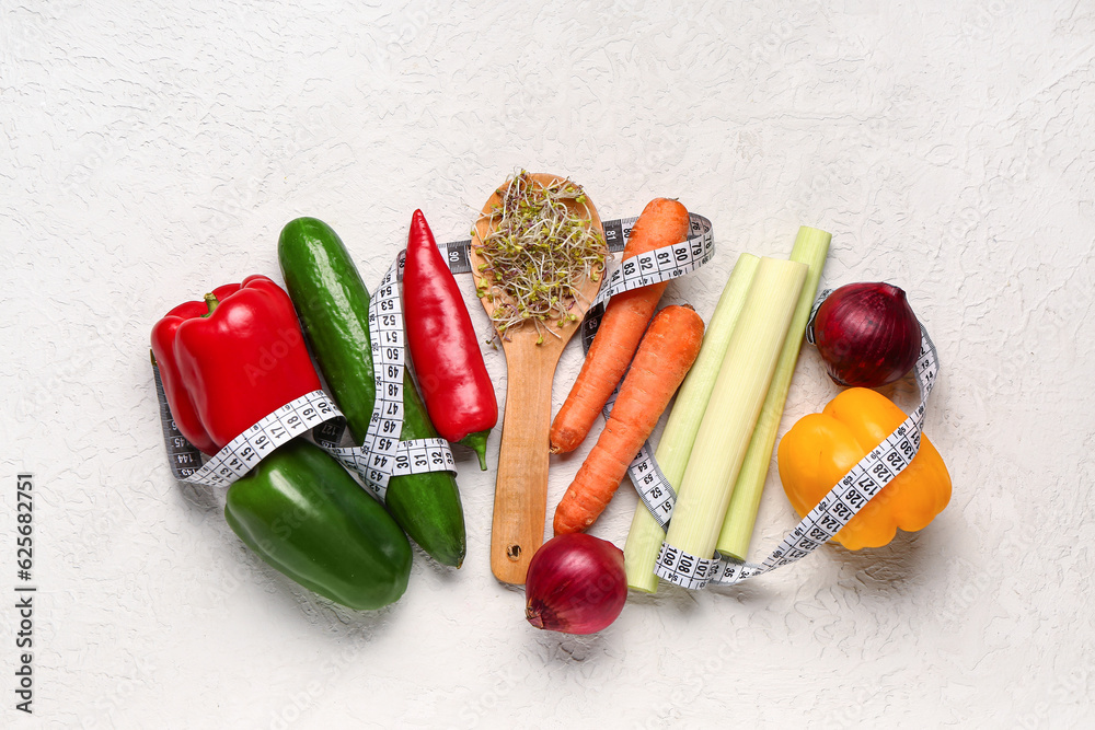 Wooden spoon with microgreen sprouts, fresh vegetables and measuring tape on light background. Diet 