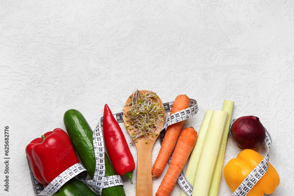 Wooden spoon with microgreen sprouts, fresh vegetables and measuring tape on light background. Diet 