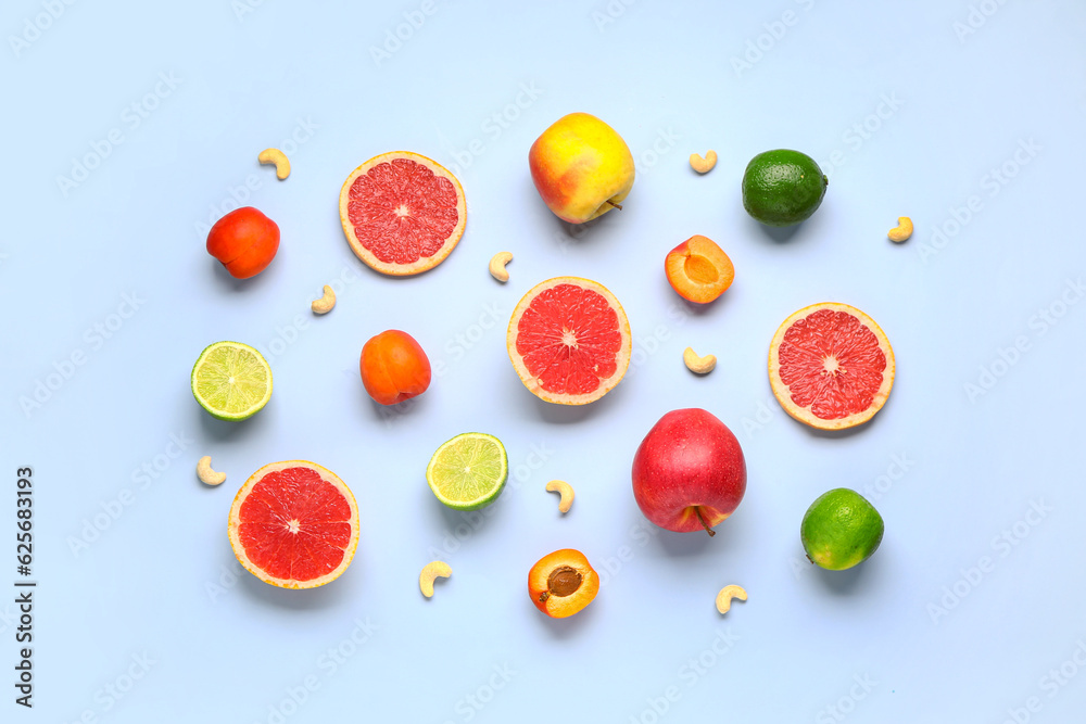 Different fresh fruits and nuts on blue background