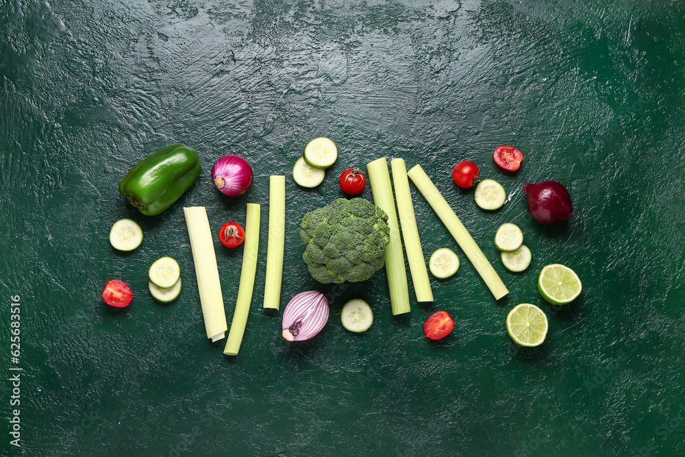 Different fresh vegetables and fruits on green background