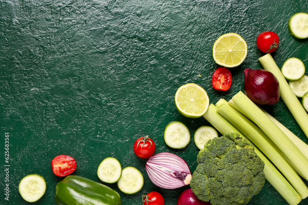 Frame made of different fresh vegetables on green background