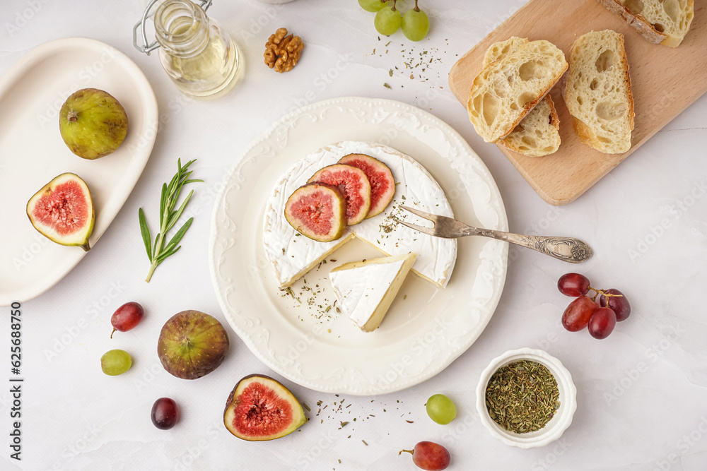 Plate with pieces of tasty Camembert cheese on grey background