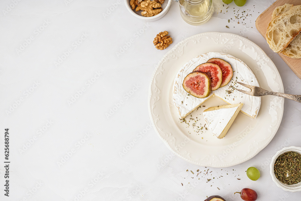 Plate with pieces of tasty Camembert cheese on grey background