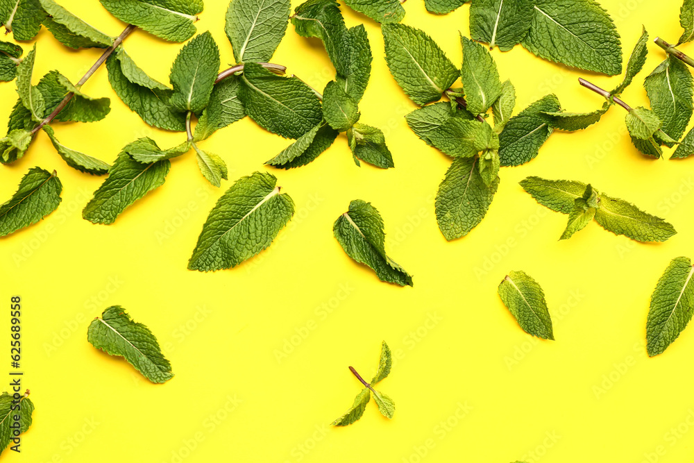 Composition with fresh mint leaves on yellow background