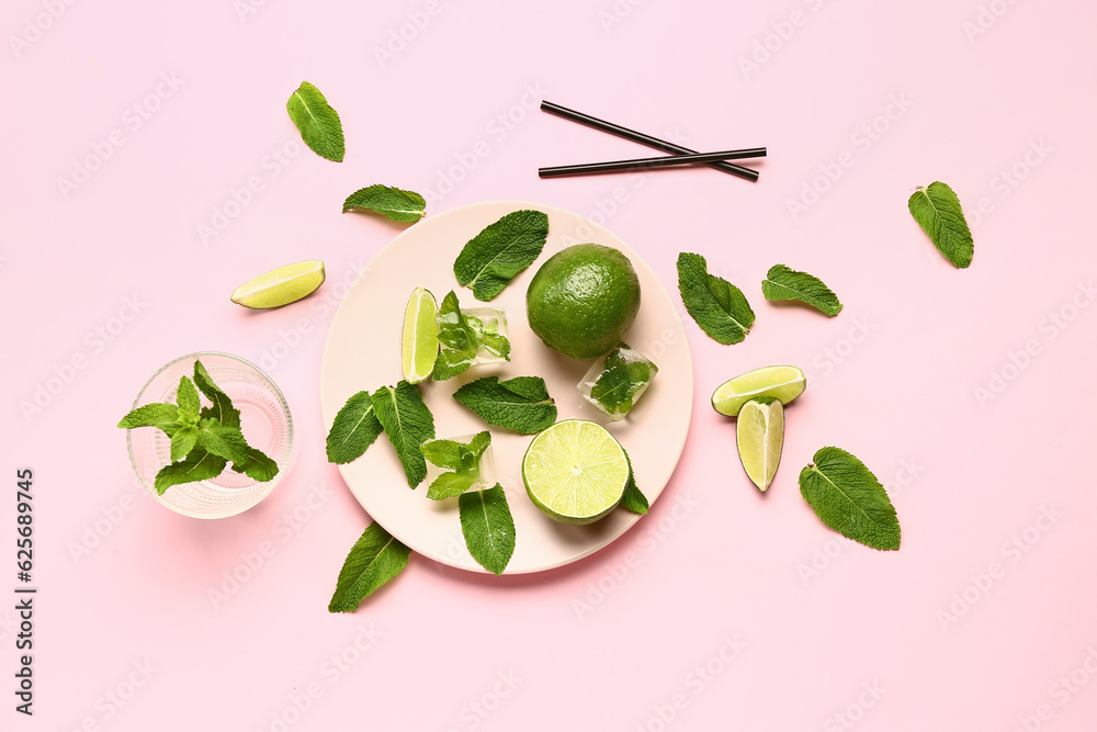 Composition with fresh mint leaves, limes and ice cubes on pink background