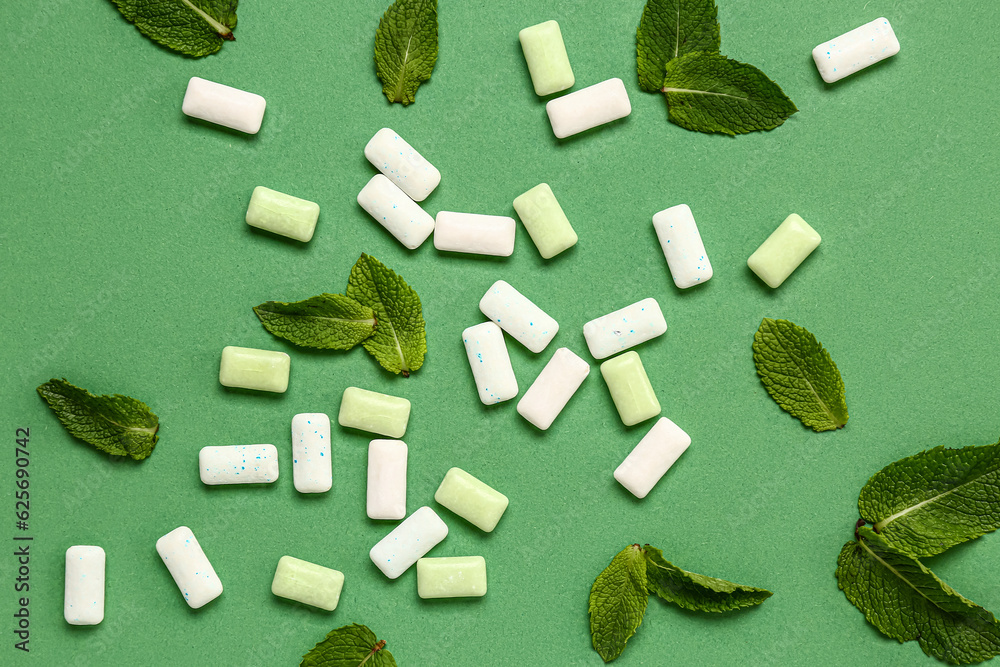 Fresh chewing gums with mint on green background