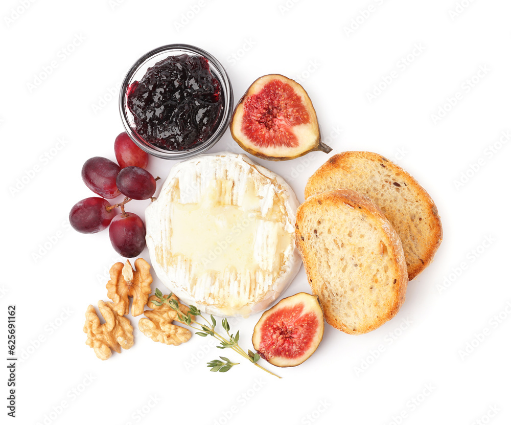 Tasty baked Camembert cheese with bread, jam, figs and grapes on white background