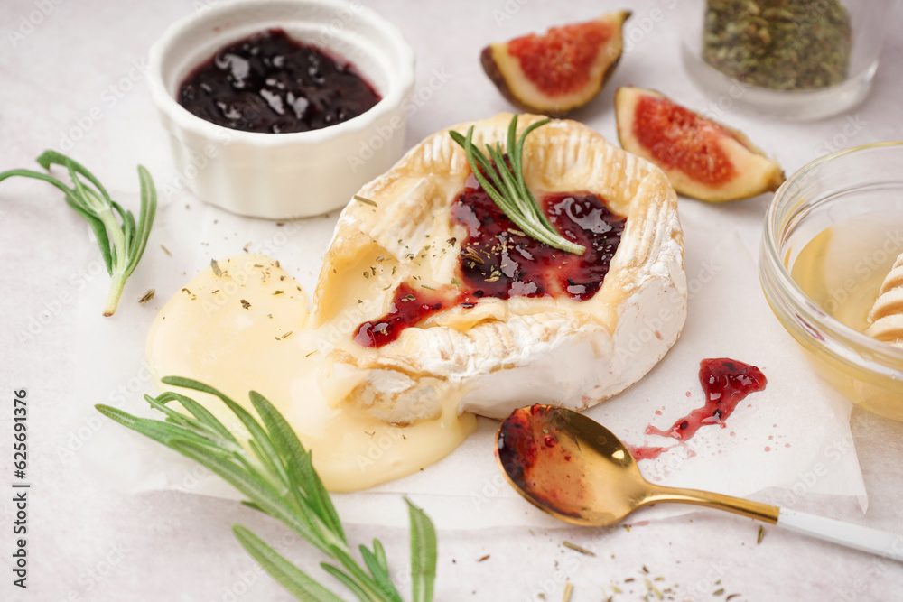 Tasty baked Camembert cheese on light background