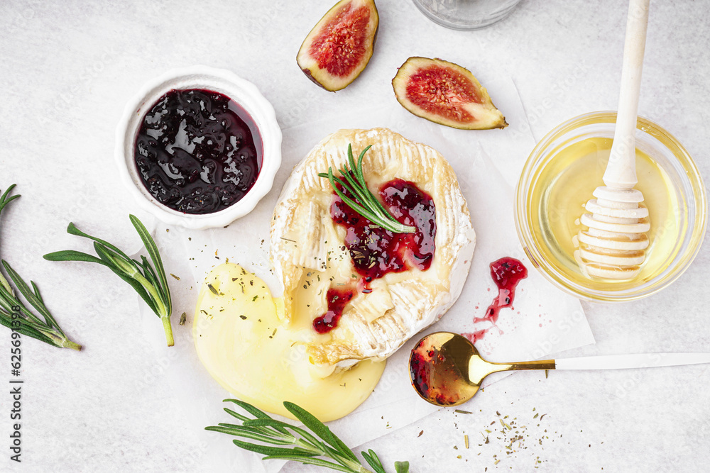 Tasty baked Camembert cheese on light background