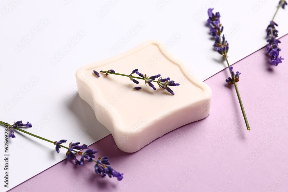 Composition with soap bar and lavender flowers on color background