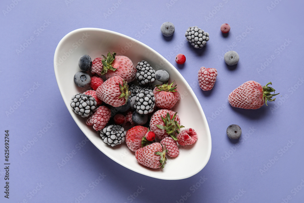 Bowl of frozen berries on purple background