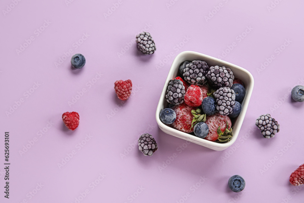 Bowl of frozen berries on purple background