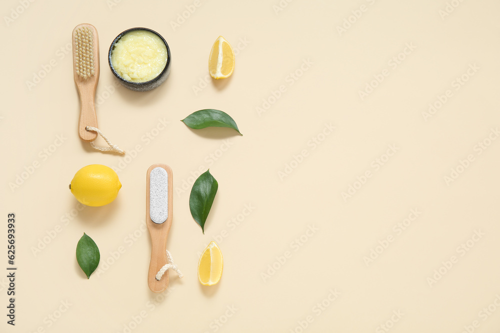 Bowl of lemon body scrub with massage brushes on beige background