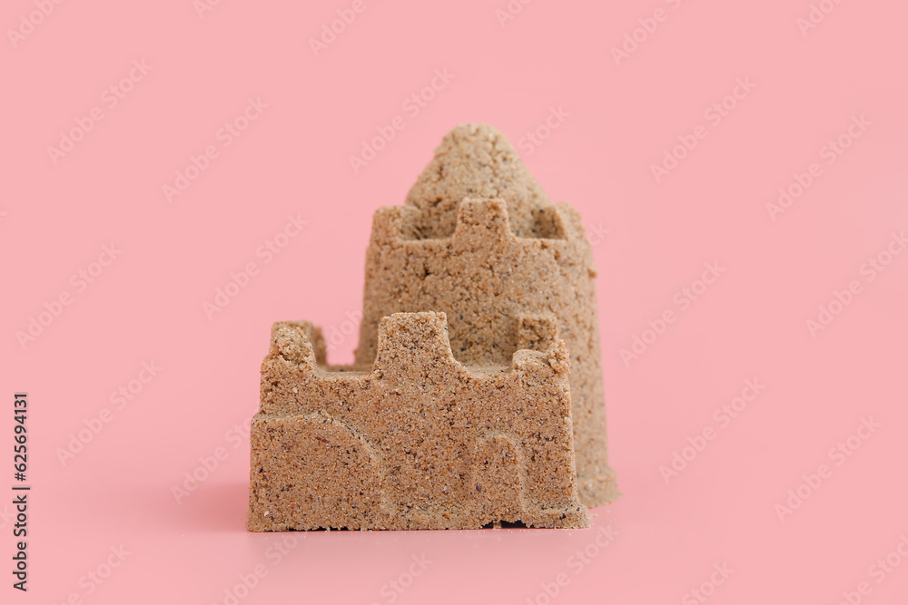 Castle made of sand on pink background