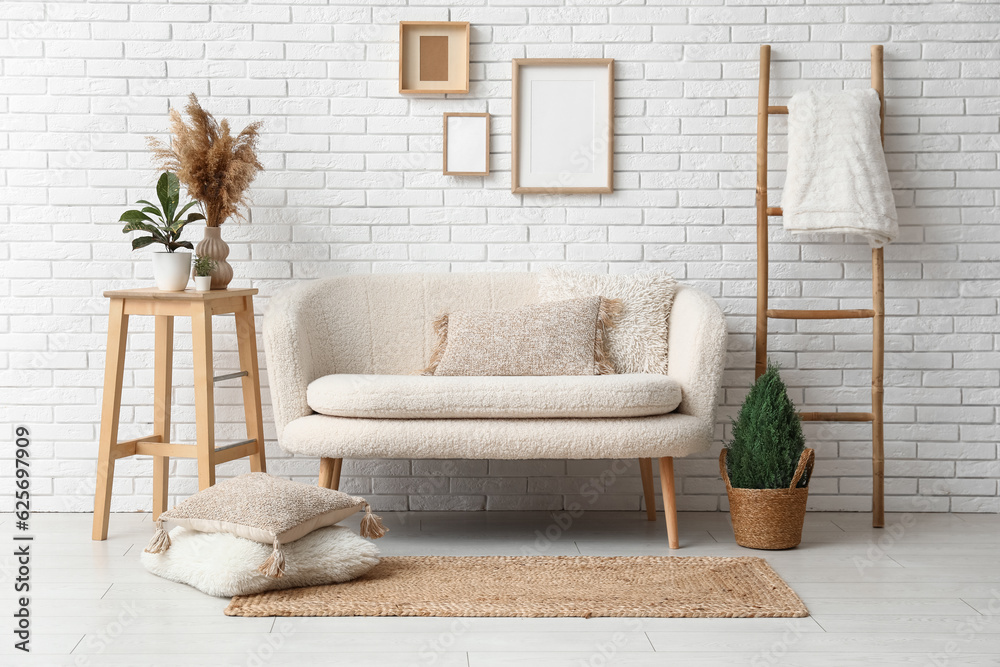 Interior of light living room with white sofa and wicker carpet