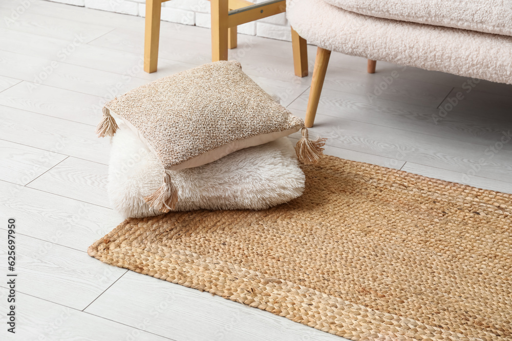 Wicker carpet with cushions in interior of living room, closeup