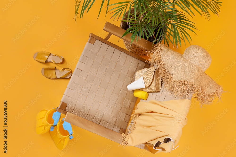 Chair with beach accessories, sunscreen cream and palm tree on color background