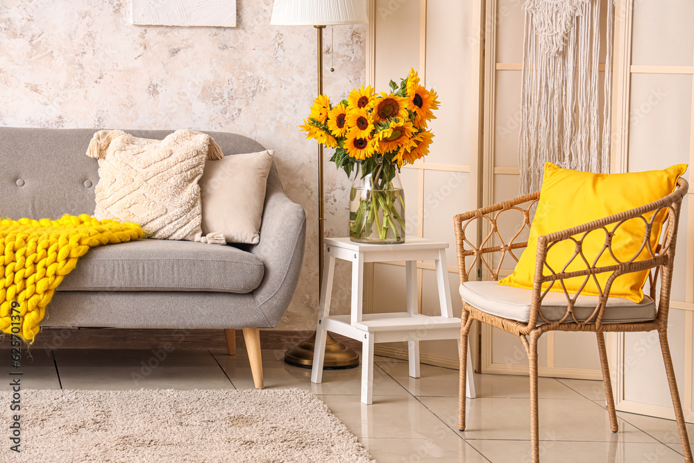 Vase with beautiful sunflowers on table in interior of light living room, closeup