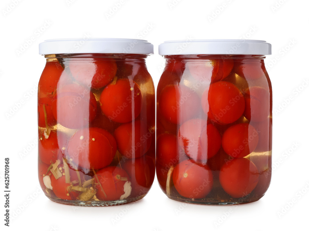 Jars with canned tomatoes on white background