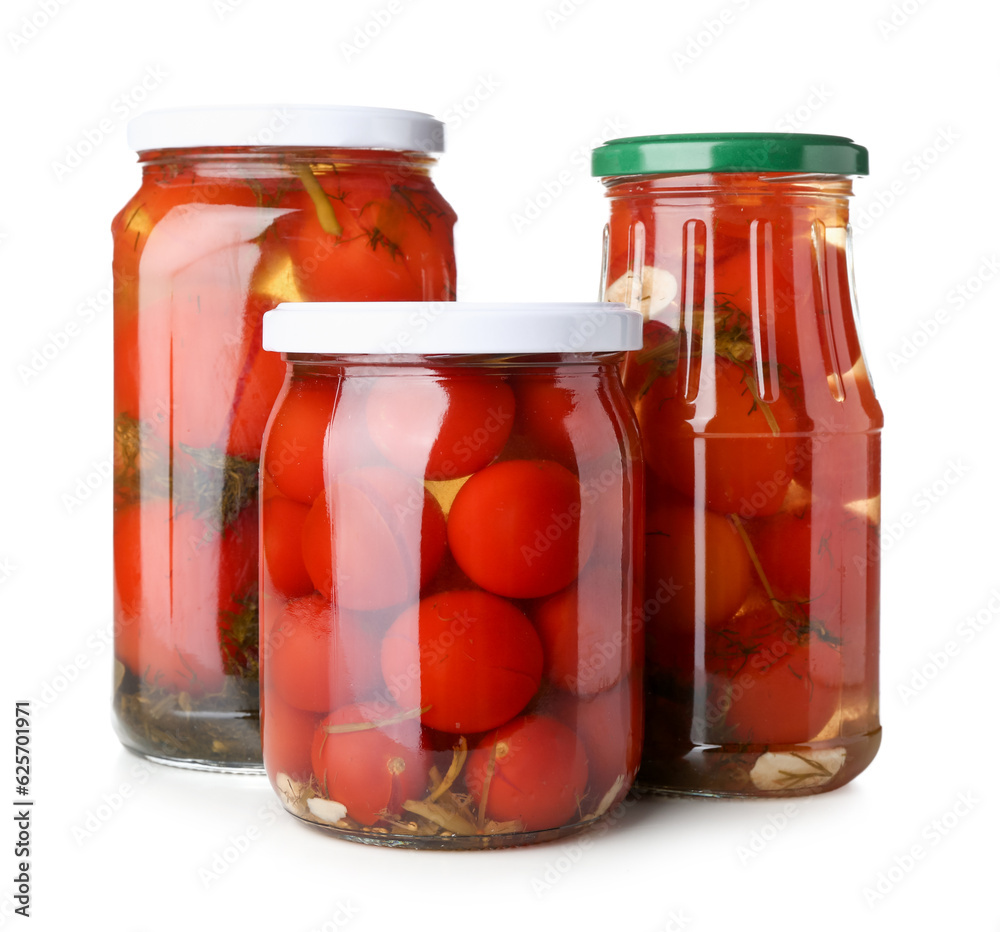 Jars with canned tomatoes on white background