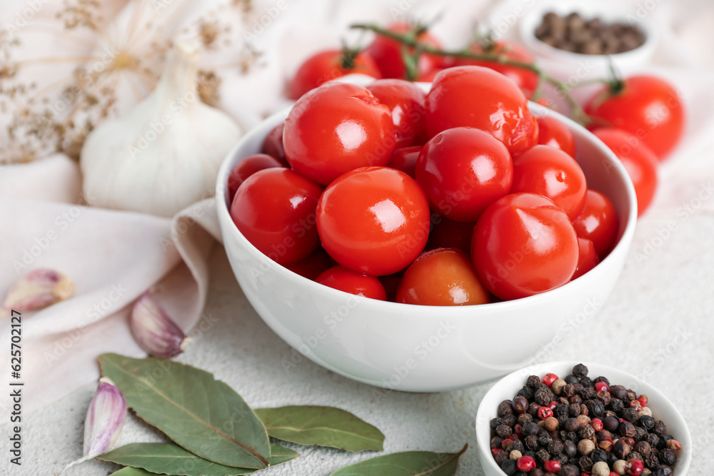 Bowl with canned tomatoes and peppercorn on white background