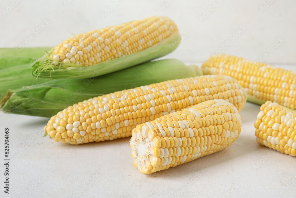 Fresh corn cobs on light background