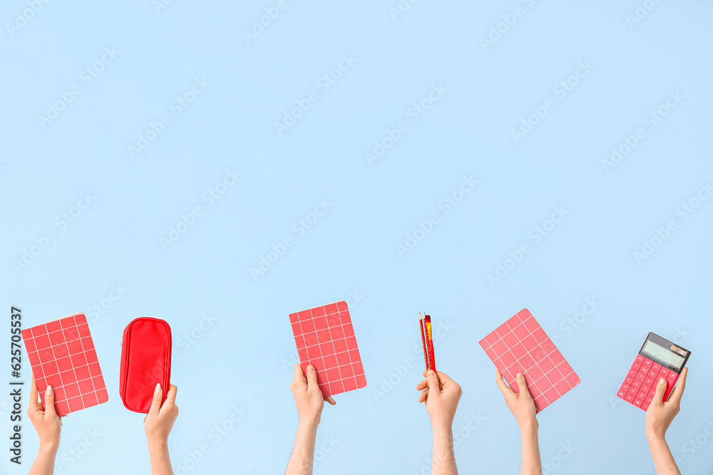 Hands with school supplies on blue background